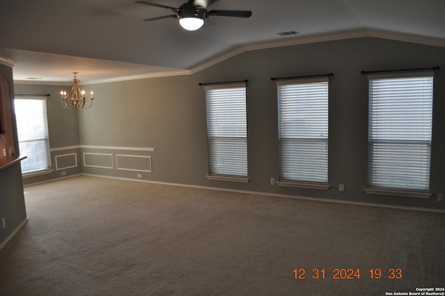 carpeted spare room featuring lofted ceiling, ceiling fan with notable chandelier, and crown molding