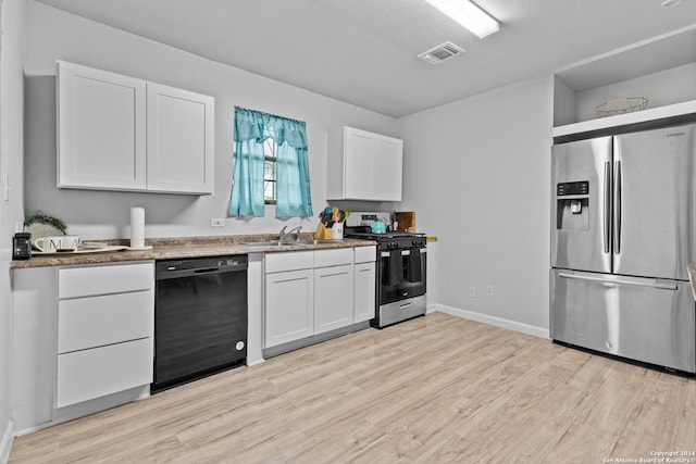 kitchen with light wood-type flooring, stainless steel appliances, white cabinetry, and sink