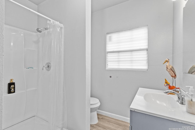 bathroom with a shower with curtain, vanity, hardwood / wood-style flooring, and toilet