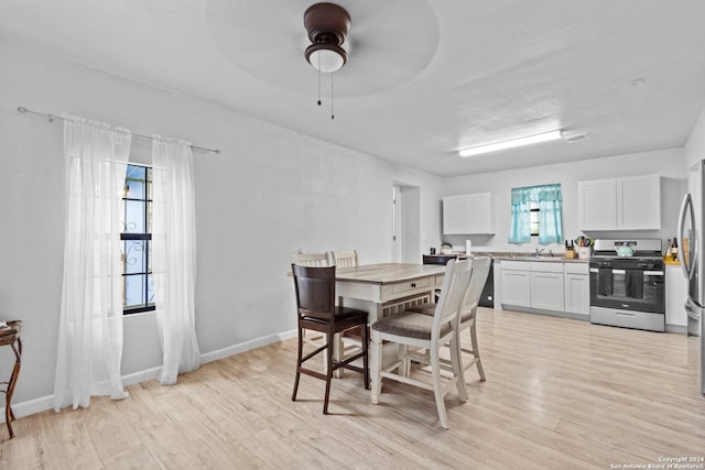 dining area with light hardwood / wood-style flooring, ceiling fan, and sink