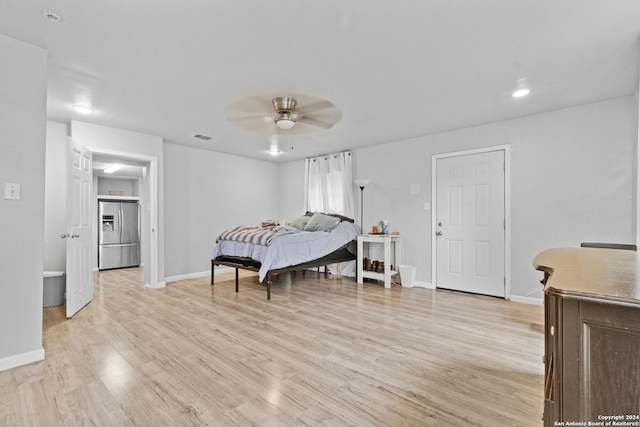 bedroom with stainless steel refrigerator with ice dispenser, light hardwood / wood-style flooring, and ceiling fan