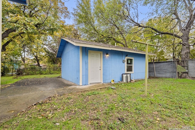 view of outdoor structure with cooling unit and a lawn