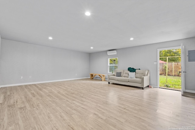 living room featuring a wall mounted AC and light hardwood / wood-style floors