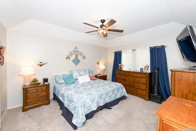 carpeted bedroom featuring a textured ceiling and ceiling fan