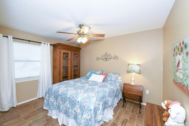 bedroom featuring a textured ceiling, hardwood / wood-style flooring, and ceiling fan