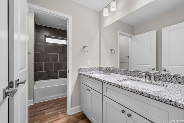 bathroom with vanity, wood-type flooring, and tiled shower / bath combo