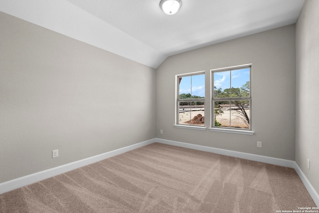 unfurnished room featuring carpet floors and vaulted ceiling