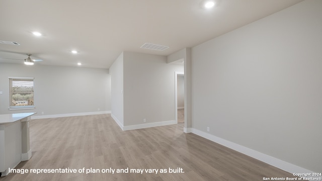 empty room with ceiling fan and light hardwood / wood-style floors