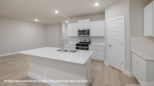 kitchen featuring sink, white cabinetry, stainless steel appliances, and an island with sink