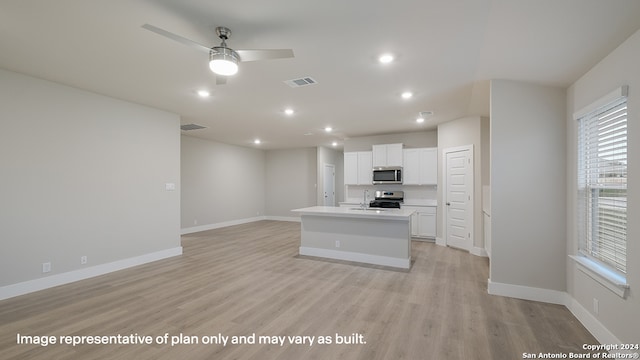 kitchen with white cabinets, ceiling fan, an island with sink, appliances with stainless steel finishes, and light hardwood / wood-style floors