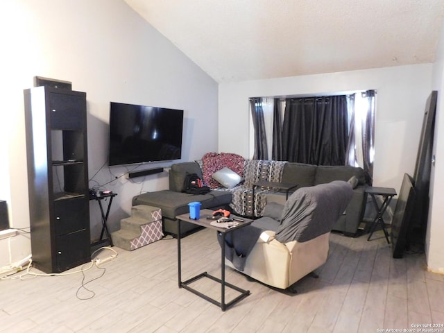 living room featuring vaulted ceiling and light hardwood / wood-style flooring