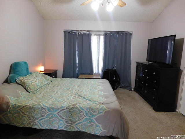 bedroom featuring a textured ceiling, ceiling fan, lofted ceiling, and light carpet