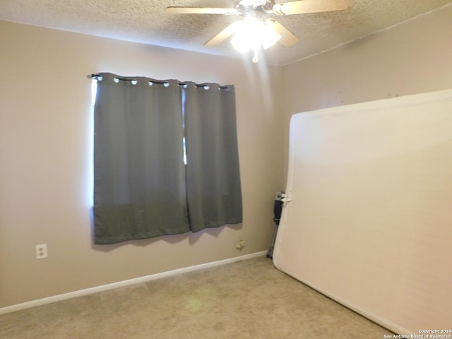 unfurnished room with ceiling fan, carpet, and a textured ceiling