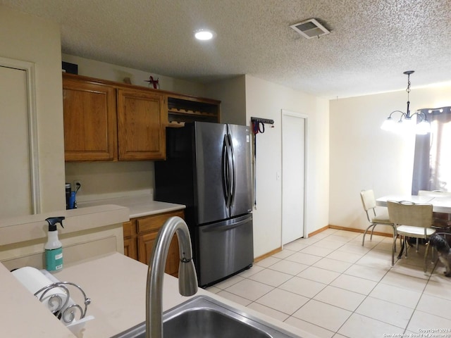 kitchen featuring hanging light fixtures, a notable chandelier, stainless steel fridge, a textured ceiling, and light tile patterned floors