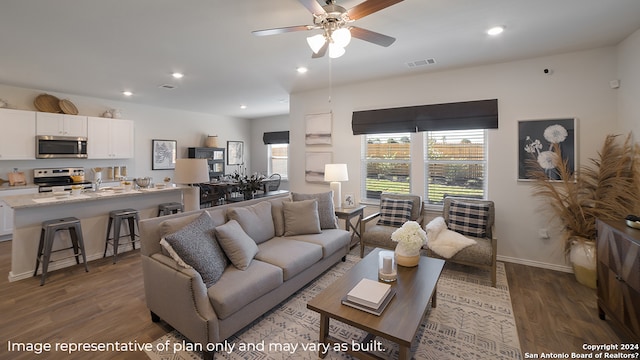 living room featuring ceiling fan and dark wood-type flooring