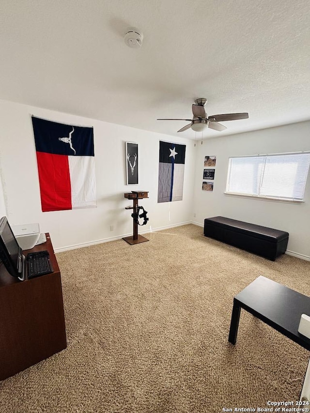 living room with a textured ceiling, carpet floors, and ceiling fan