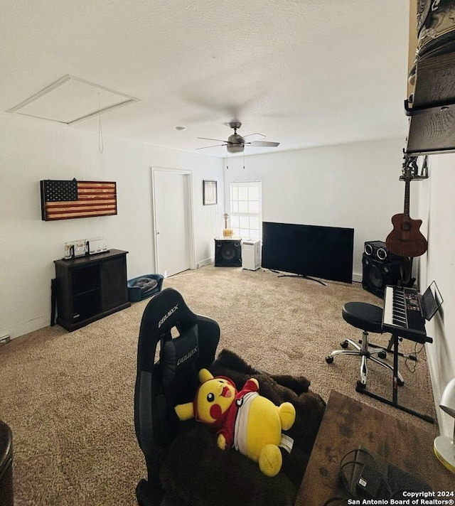 carpeted living room featuring ceiling fan and a textured ceiling