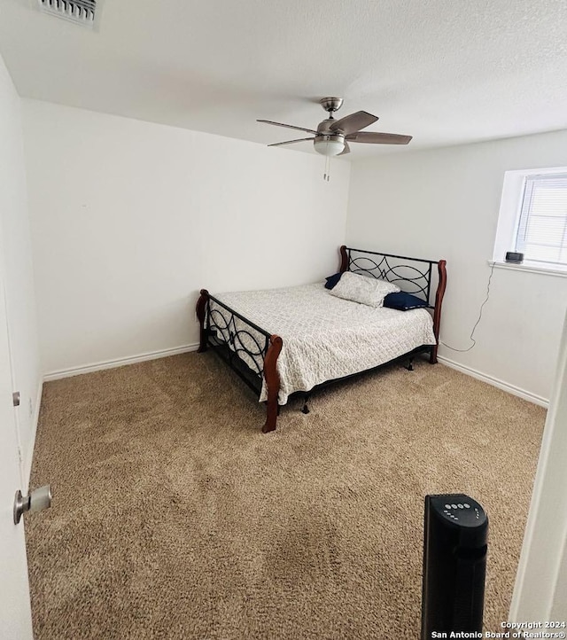 carpeted bedroom with a textured ceiling and ceiling fan