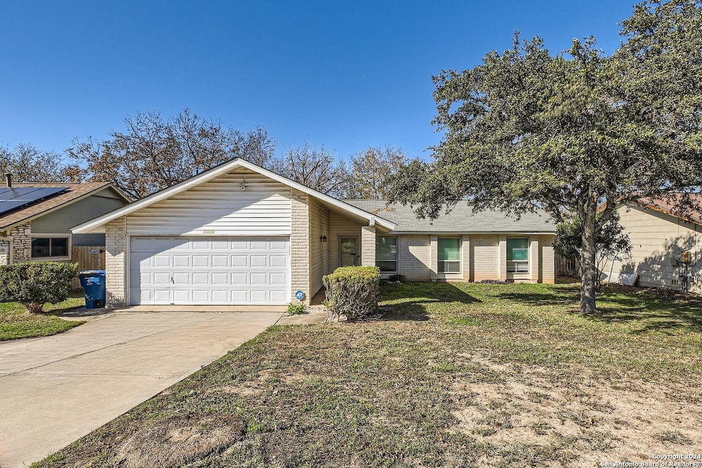 ranch-style home featuring a front lawn and a garage