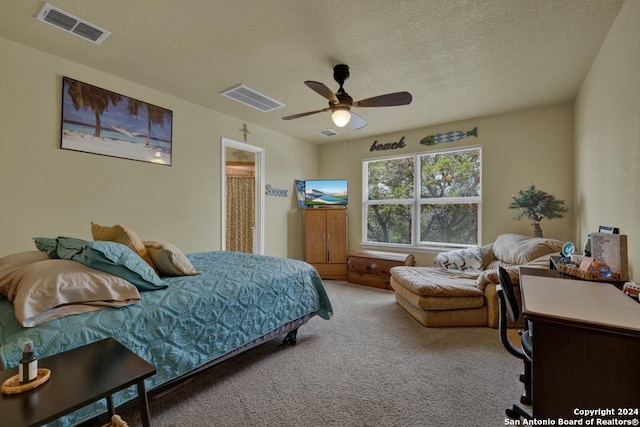 carpeted bedroom with ceiling fan and a textured ceiling