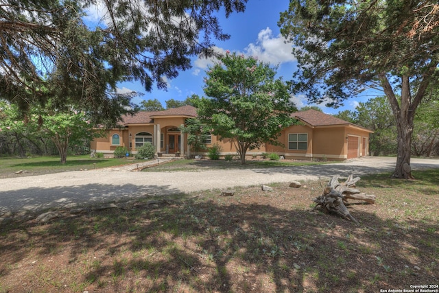 mediterranean / spanish house featuring a front yard and a garage