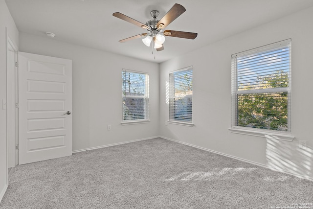 unfurnished room with ceiling fan, light colored carpet, and a healthy amount of sunlight