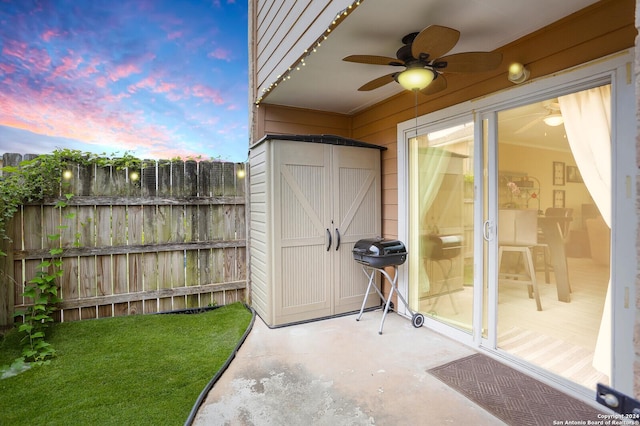 exterior space featuring a grill, ceiling fan, a yard, and a storage unit