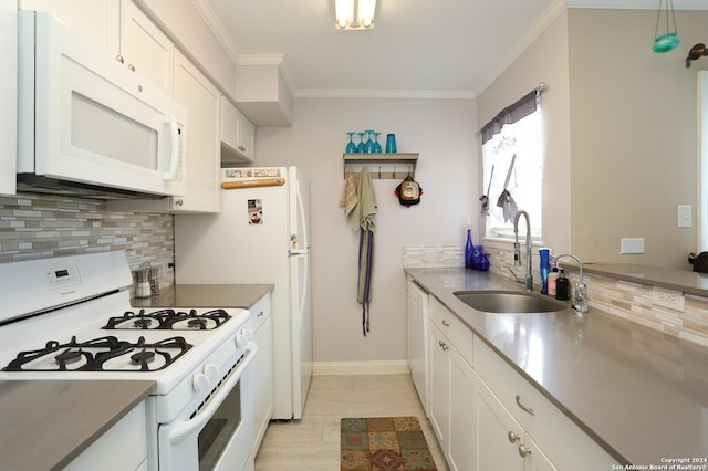 kitchen with white appliances, crown molding, sink, decorative light fixtures, and white cabinets