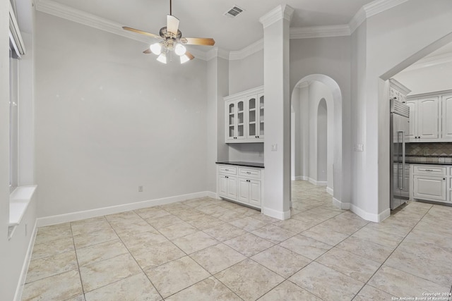 interior space with ceiling fan and ornamental molding