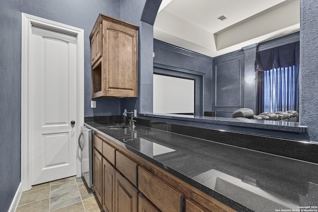 kitchen featuring dark stone countertops and sink