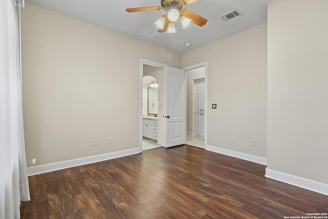 unfurnished bedroom with dark hardwood / wood-style floors, ensuite bath, and ceiling fan