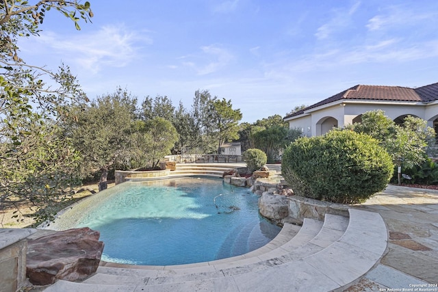 view of swimming pool with pool water feature