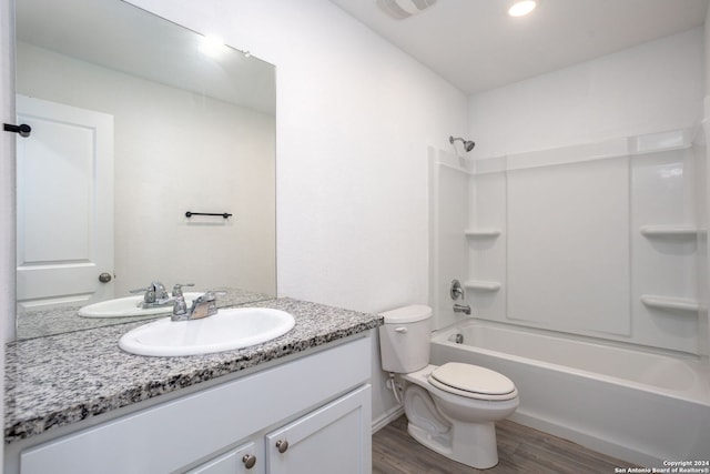 full bathroom featuring hardwood / wood-style floors, vanity, toilet, and tub / shower combination