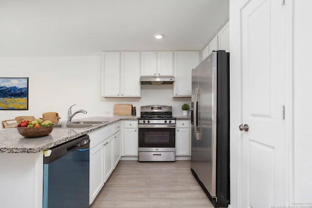 kitchen with kitchen peninsula, light wood-type flooring, stainless steel appliances, sink, and white cabinets