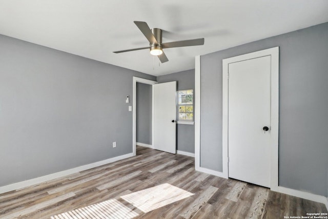 unfurnished bedroom featuring hardwood / wood-style floors and ceiling fan