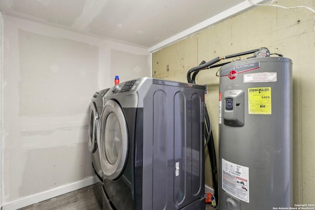 laundry room with water heater and washer and dryer