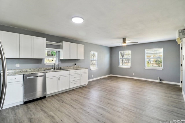 kitchen with dishwasher, white cabinets, sink, ceiling fan, and light stone countertops