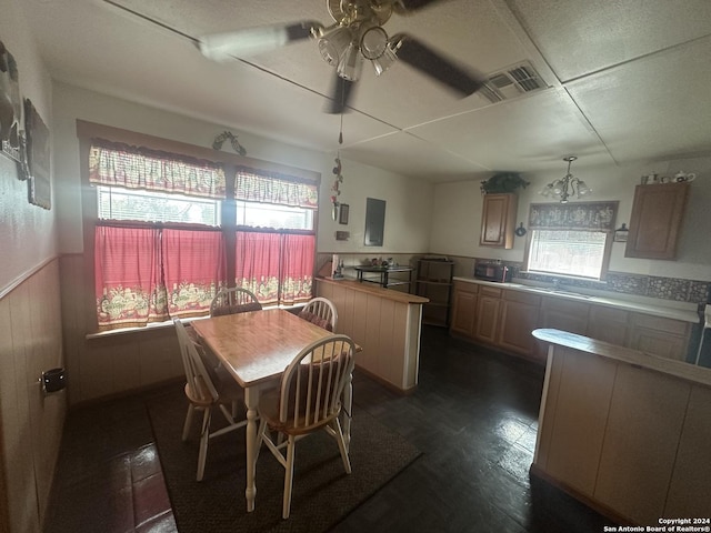 dining area featuring visible vents, a wainscoted wall, wood walls, and ceiling fan