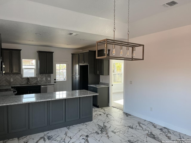 kitchen with light stone counters, sink, tasteful backsplash, and dishwasher