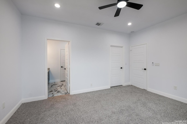 unfurnished bedroom featuring light colored carpet, ceiling fan, and ensuite bathroom