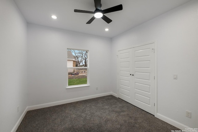 unfurnished bedroom with dark colored carpet, ceiling fan, and a closet