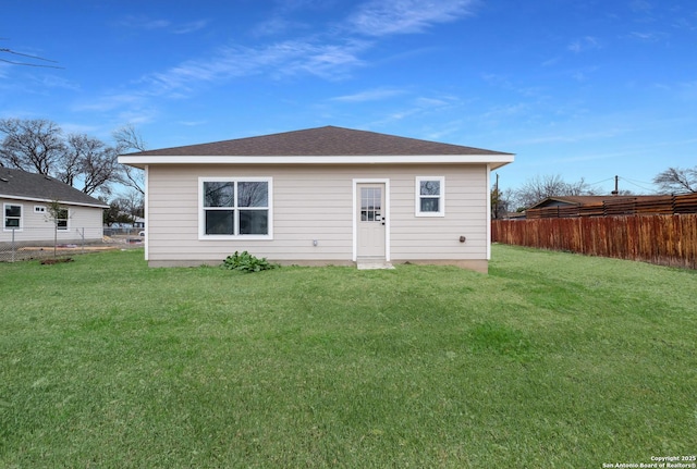 rear view of property featuring a yard