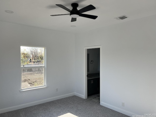 carpeted spare room featuring ceiling fan