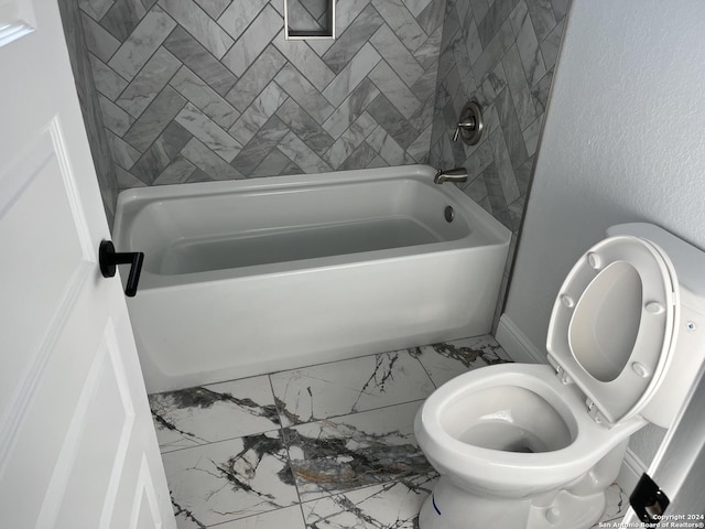 bathroom featuring tiled shower / bath and toilet