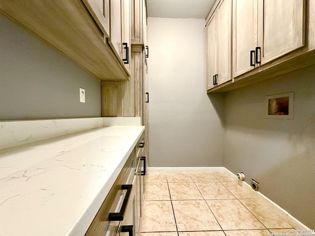 laundry room featuring washer hookup, light tile patterned flooring, and cabinets