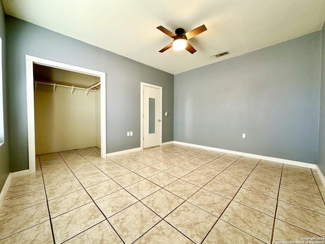 unfurnished bedroom featuring light tile patterned floors, a closet, and ceiling fan