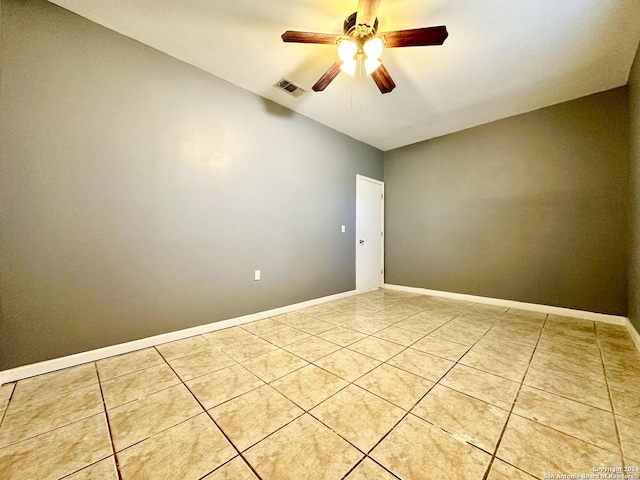 spare room with ceiling fan and light tile patterned floors