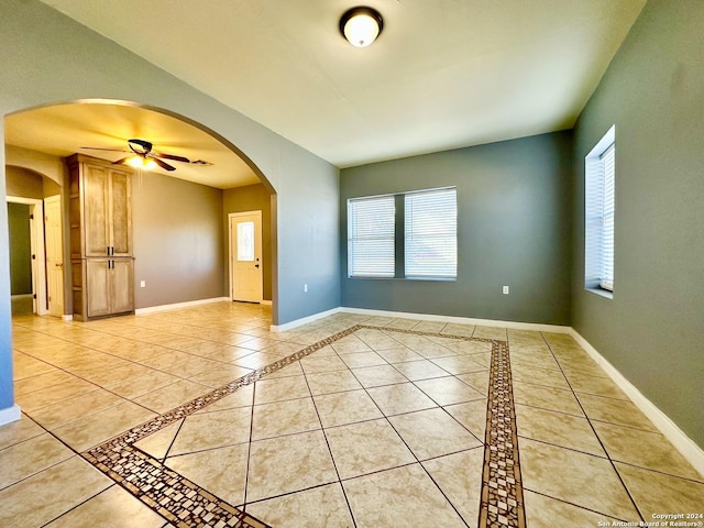 tiled spare room with ceiling fan