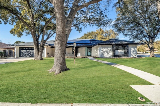 single story home featuring a garage, a front yard, and solar panels