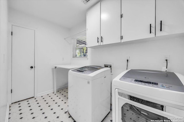 washroom featuring cabinets and washing machine and clothes dryer